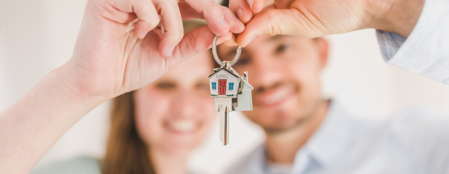 Couple holding key to home